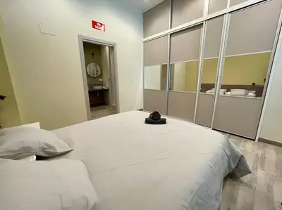 a bedroom with a large white bed with a mirror at Sensacional apartamento en Ruzafa in Valencia