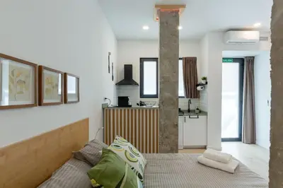 a bedroom with a bed and a kitchen at Loft nuevo cerca de Ruzafa y Ciudad de las Artes in Valencia