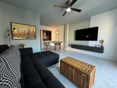 a living room with a couch and a flat screen tv at Cullera Beach Oasis in Cullera