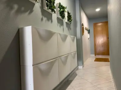 a hallway with a white refrigerator against a wall at Cullera Beach Oasis in Cullera