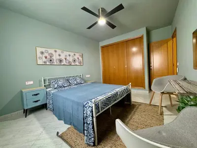 a bedroom with a bed and a ceiling fan at Cullera Beach Oasis in Cullera
