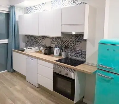 a kitchen with white cabinets and a stove top oven at Amplio y colorido piso in Valencia