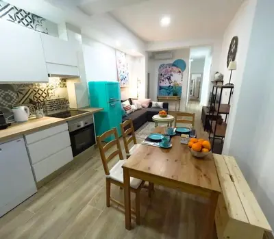 a kitchen and living room with a table and chairs at Amplio y colorido piso in Valencia
