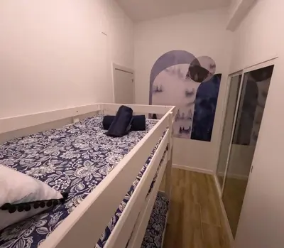 a bedroom with a large bed with a black pillow on it at Amplio y colorido piso in Valencia