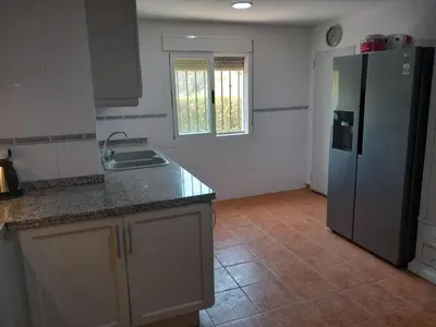 a kitchen with a stainless steel refrigerator and a tile floor at The Villarosa in Turís