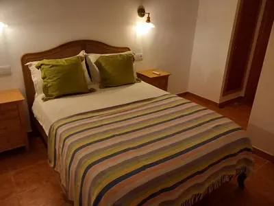 a bedroom with a large bed with green pillows at The Villarosa in Turís