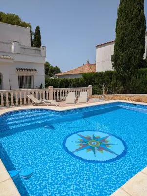 a large blue swimming pool with chairs around it at Chalet independiente con piscina in Partida de La Cañada