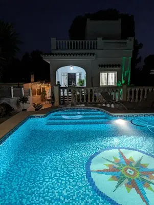 a swimming pool in front of a house at night at Chalet independiente con piscina in Partida de La Cañada