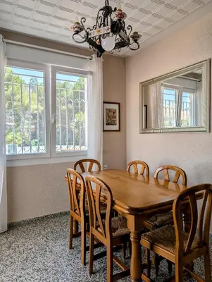 a dining room with a wooden table and chairs at Chalet independiente con piscina in Partida de La Cañada