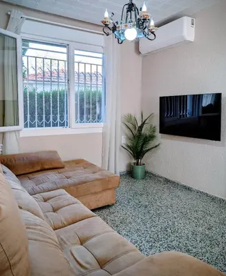 a living room with a couch and a flat screen tv at Chalet independiente con piscina in Partida de La Cañada