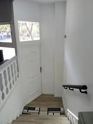 a white hallway with a door and a window at Apartamento Plaza Palmeras in Burjasot