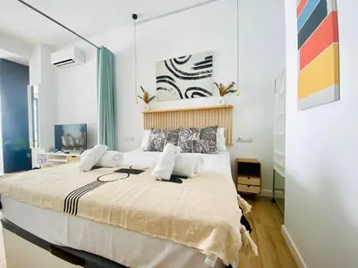 a bedroom with a large bed with white walls at BAJO A - Design & Comfort in Ruzafa SOHO in Valencia