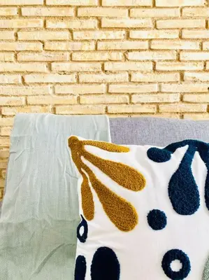 a polka dot pillow on a couch next to a brick wall at BAJO A - Design & Comfort in Ruzafa SOHO in Valencia