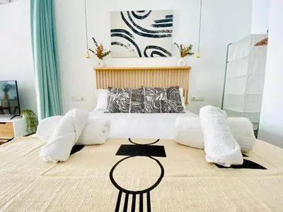a bedroom with a large white bed and a table at BAJO A - Design & Comfort in Ruzafa SOHO in Valencia