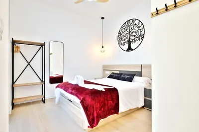a bedroom with a white bed with a red blanket at Apartamento RD A in Valencia