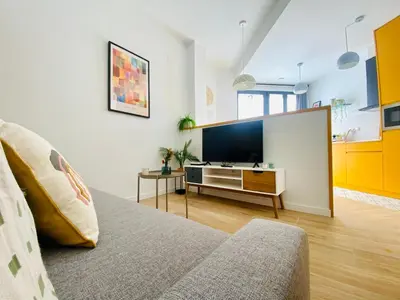 a living room with a couch and a flat screen tv at BAJO B - Design & Comfort in Ruzafa SOHO in Valencia