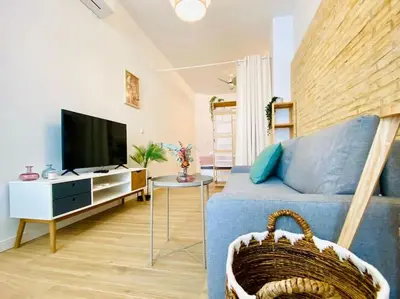 a living room with a blue couch and a tv at BAJO C - Design & Comfort in Ruzafa SOHO in Valencia