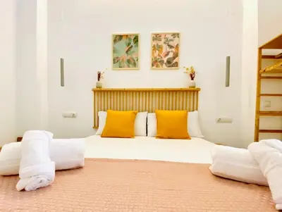 a bedroom with a large bed with yellow pillows at BAJO C - Design & Comfort in Ruzafa SOHO in Valencia
