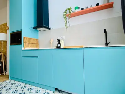 a kitchen with blue cabinets and a tile floor at BAJO C - Design & Comfort in Ruzafa SOHO in Valencia