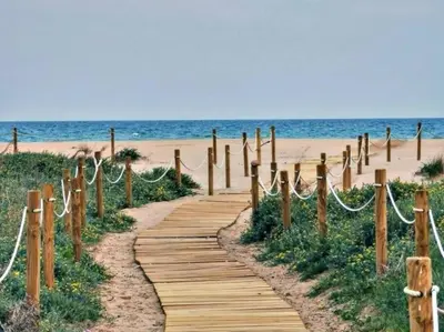 a wooden path leading to the beach at Moderno estudio a 2 minutos de la Playa Sagunto A3 in Puerto de Sagunto