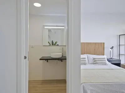 a bedroom with a bed with a sink and a mirror at Moderno estudio a 2 minutos de la Playa Sagunto A3 in Puerto de Sagunto