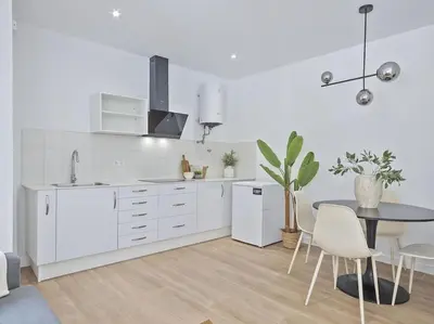 a white kitchen with a table and a dining room at Refugio Costero a 2 minutos de Playa Sagunto A4 in Puerto de Sagunto