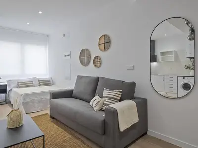 a living room with a couch and a mirror at Escondite a 2 minutos de playa de Sagunto A5 in Puerto de Sagunto