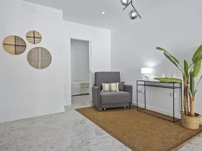 a living room with a chair and a table at Oasis Junto al Mar a 2 minutos de playa Sagunto A6 in Puerto de Sagunto