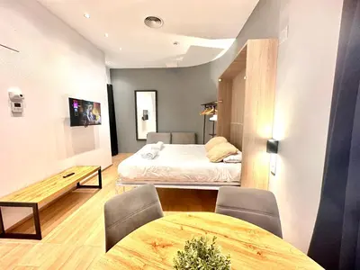a room with a bed and a table and chairs at Place Your Place SUITES Benimaclet in Valencia
