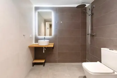 a bathroom with a toilet and a sink and a mirror at Place Your Place SUITES Benimaclet in Valencia