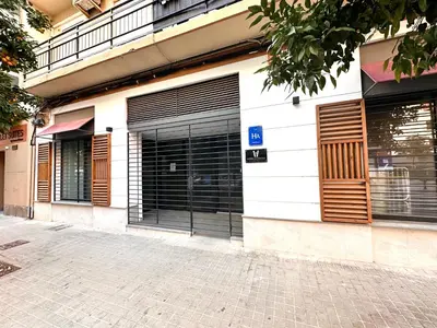 a building with black garage doors on a street at Place Your Place SUITES Benimaclet in Valencia
