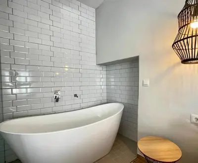 a white bath tub in a bathroom with white tiles at ESTUDIO CON JACCUZI Y SAUNA montaña y playa in Tavernes de Valldigna