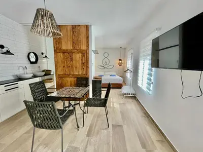 a kitchen and dining room with a table and chairs at ESTUDIO CON JACCUZI Y SAUNA montaña y playa in Tavernes de Valldigna