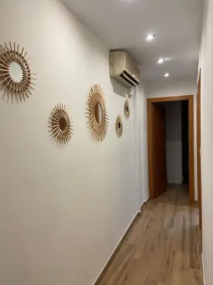 a hallway with three mirrors on a white wall at Casa de ensueño a 5 minutos de la playa in Valencia