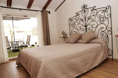 a bedroom with a large bed with a wrought iron headboard at Casa de ensueño a 5 minutos de la playa in Valencia
