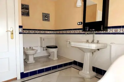 a bathroom with a sink and a toilet and a mirror at Casa de ensueño a 5 minutos de la playa in Valencia