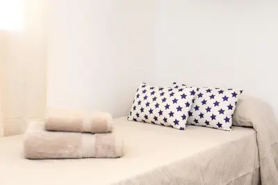 a white couch with two pillows on top of it at UrbanNest Apartment in Valencia