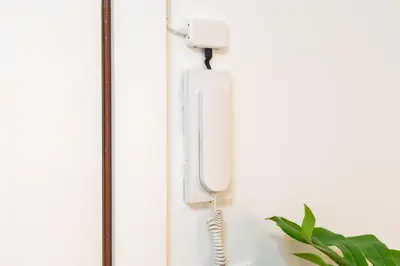 a white phone hanging on a wall at UrbanNest Apartment in Valencia