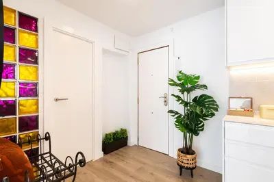 a kitchen with white walls and a plant next to a door at UrbanNest Apartment in Valencia