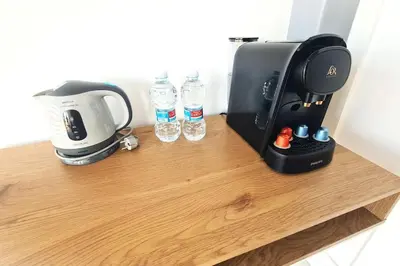 a coffee maker and water bottles on a wooden table at E-Arenas Apartment with terrace in Edificio Arenas in Valencia