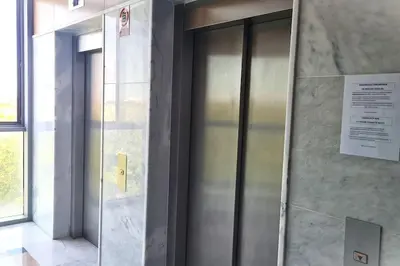 a glass elevator in a building with a sign on it at E-Arenas Apartment with terrace in Edificio Arenas in Valencia