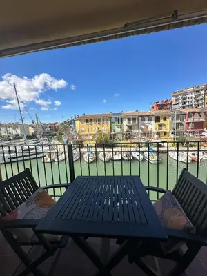 a table and chairs on a balcony with a view of a harbor at Port Saplaya 2 habitaciones Valencia in Port Saplaya