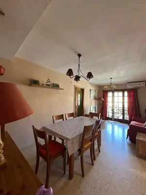 a dining table and chairs in a living room at Port Saplaya 2 habitaciones Valencia in Port Saplaya