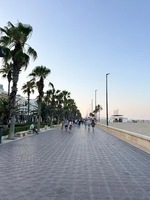 a group of people walking down a sidewalk near the beach at Barco muy espacioso con dos terrazas Valencia CENTRO!! in Valencia