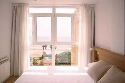 a bedroom with a large window with a view of the beach at Luminoso estudio con vistas al mar in Las Canteras