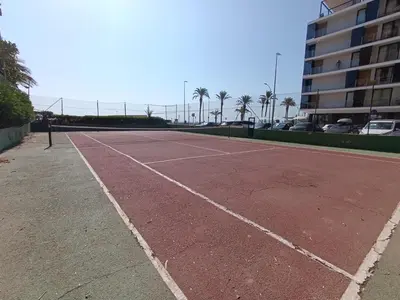 an empty tennis court in front of a building at Luminoso estudio con vistas al mar in Las Canteras