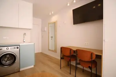 a kitchen with a table and a washing machine at Luminoso estudio con vistas al mar in Las Canteras