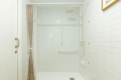 a shower in a white tiled bathroom with a toilet at Nuevo loft cerca del centro y Ciudad Artes y Ciencias in Valencia