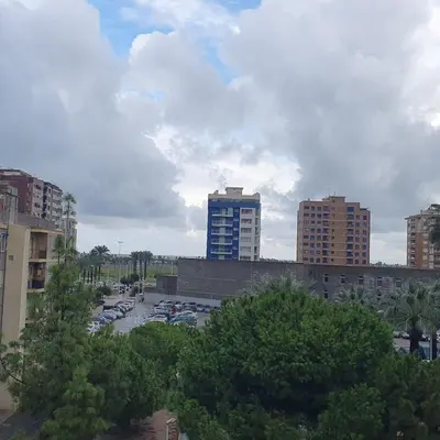 a parking lot with parked cars in a city at Apartamento Berenguer in Cullera