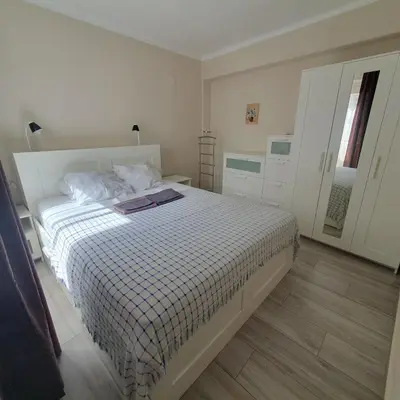 a bedroom with a white bed and a bathroom at Apartamento Berenguer in Cullera